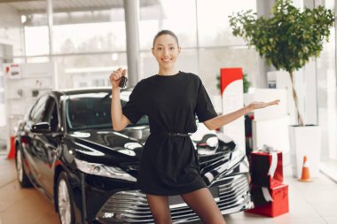 Bir araba galerisinde şık ve zarif bir kadın.