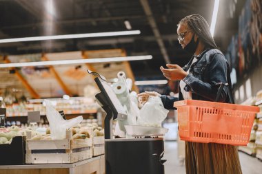 Maskeli siyah kız yiyecek al.