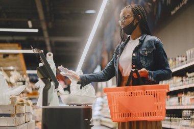 Maskeli siyah kız yiyecek al.