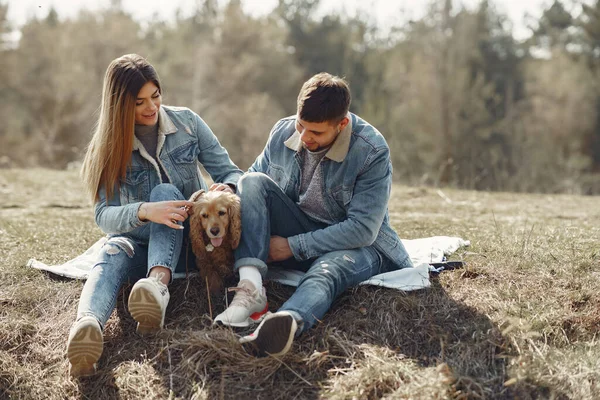 Aranyos pár farmerruhában egy tavaszi mezőn. — Stock Fotó