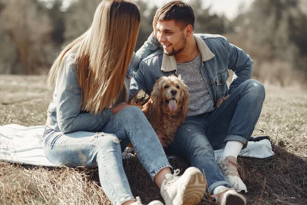 Aranyos pár farmerruhában egy tavaszi mezőn. — Stock Fotó