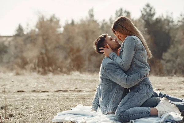 Coppia carina in vestiti di jeans in un campo di primavera — Foto Stock