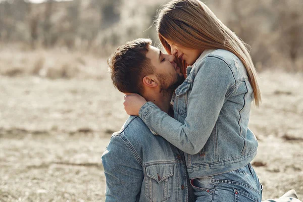 Aranyos pár farmerruhában egy tavaszi mezőn. — Stock Fotó