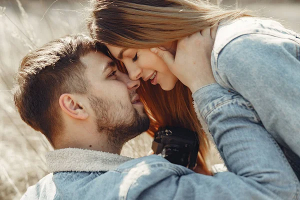 Linda pareja en una ropa vaquera en un campo de primavera — Foto de Stock