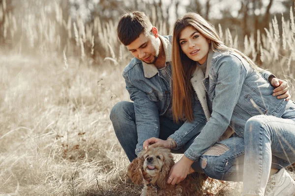 Schattig paar in een jeans kleding in een lente veld — Stockfoto