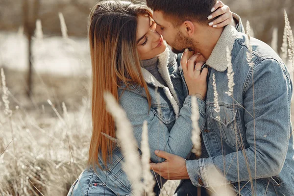 Linda pareja en una ropa vaquera en un campo de primavera — Foto de Stock