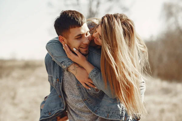 Cute couple in a jeans clothes in a spring field — Stock Photo, Image