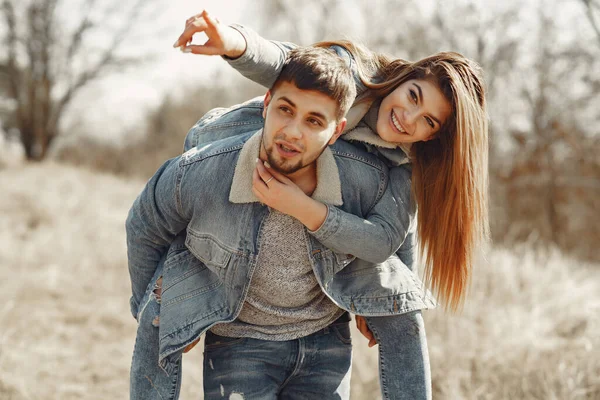 Casal bonito em uma roupa de calça em um campo de primavera — Fotografia de Stock