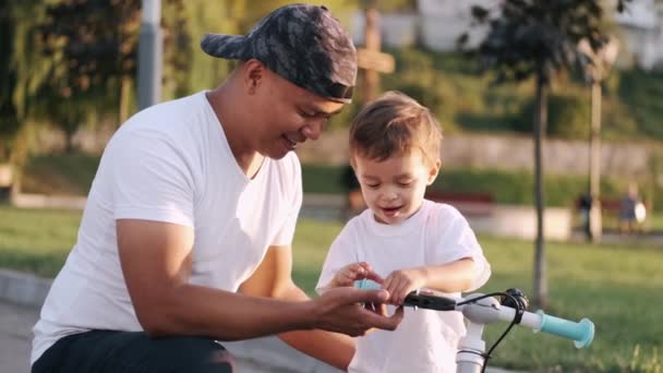 Ayah mengajar anak untuk mengendarai sepeda di taman musim panas — Stok Video