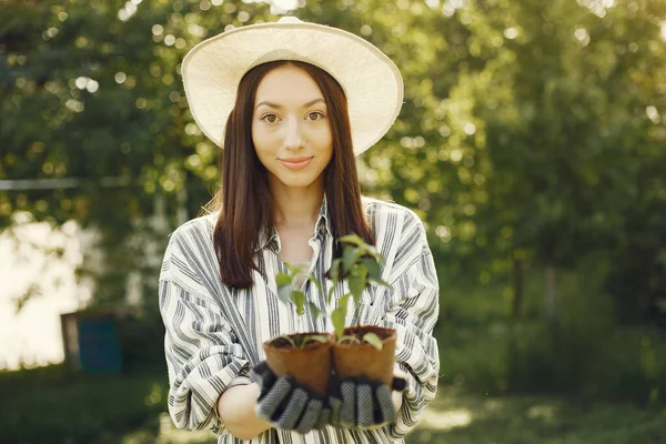 Wanita dalam topi memegang pot bunga. — Stok Foto