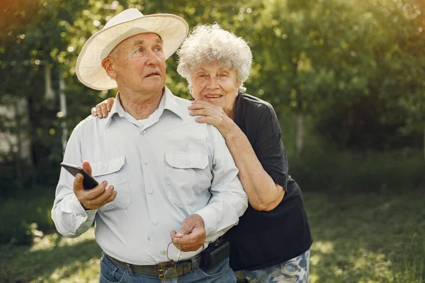 Beautiful old couple spend time in a summer garden — Stock Photo, Image