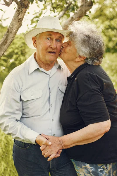 Beautiful old couple spend time in a summer garden — Stock Photo, Image