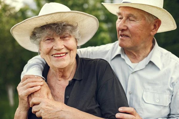 Beautiful old couple spend time in a summer garden — Stock Photo, Image