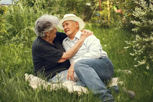 Beautiful old couple spend time in a summer garden — Stock Photo, Image