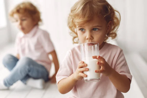 Słodkie dzieci pijące mleko w domu — Zdjęcie stockowe