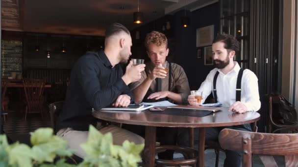 Μια ομάδα από τρεις κομψούς ευρωπαίους επιχειρηματίες φίλους επιχειρηματίες σε ένα καφέ — Αρχείο Βίντεο