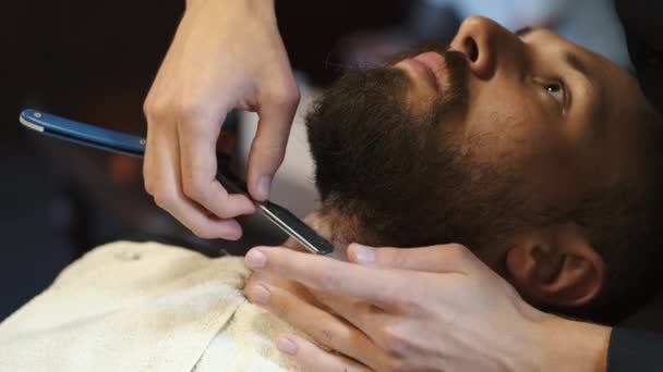 Парикмахер бреется классической бритвой — стоковое видео