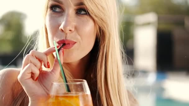 Красивая молодая женщина пьет коктейль крупным планом — стоковое видео