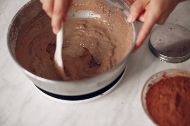 Beyaz elbiseli şef çikolatalı pasta hazırlıyor..