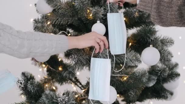 Coronavirus Face masks being hanged by women on Christmas tree — Stock Video