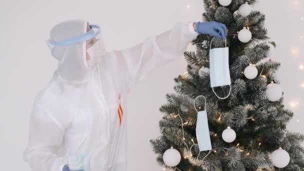Γυναίκα σε πλήρη κάλυψη κοστούμι διακόσμηση χριστουγεννιάτικο δέντρο με μάσκες — Αρχείο Βίντεο
