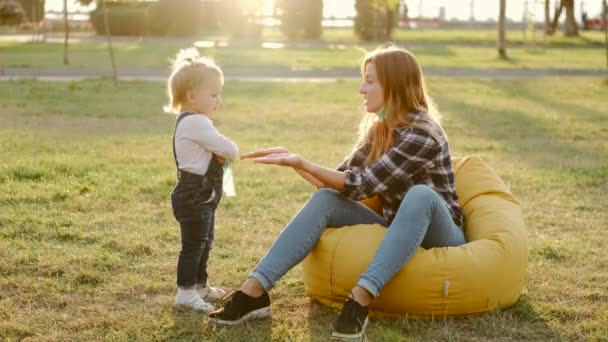 Anne ve küçük kızı güneşli havada parkta eğleniyorlar. — Stok video