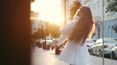 Güzel anne küçük kızını kucaklıyor ve şehirde dönüyor.