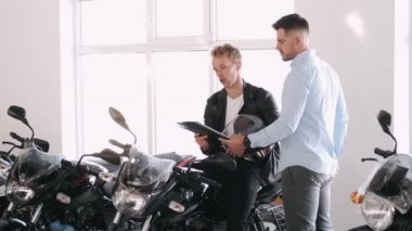 Müşteri danışmanıyla motosiklet hakkında konuşuyor.