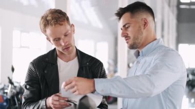 Müşteri danışmanıyla motosiklet hakkında konuşuyor.