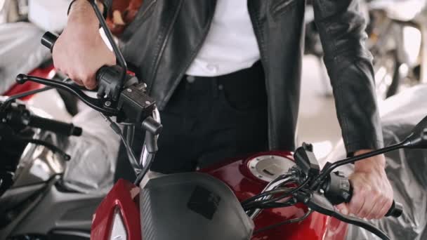 Jeune homme choisissant la moto dans un magasin — Video