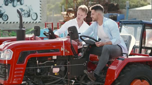 Attractive man buying a tractor at outdoor shop — Stock Video