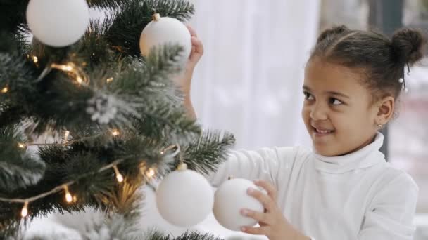 Afroamericano ragazza in bianco vestiti decorazione albero di Natale — Video Stock