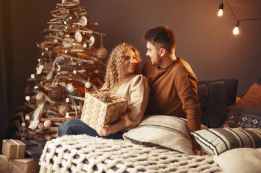 Noel ağacının yanında oturan zarif bir çift.