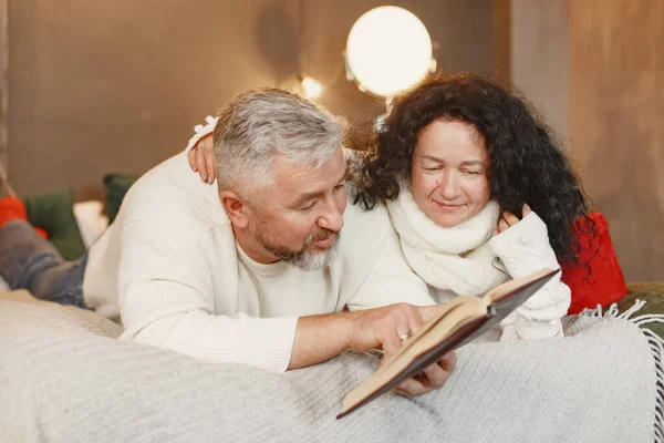 Seniorenpaar mit Geschenken sitzt auf einem Bett — Stockfoto