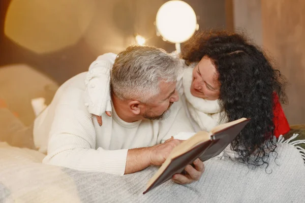 Seniorenpaar mit Geschenken sitzt auf einem Bett — Stockfoto