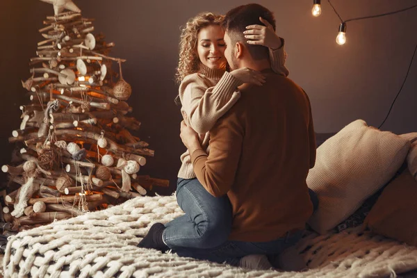 Elegante pareja sentada en casa cerca del árbol de Navidad — Foto de Stock