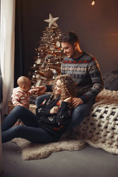 Elegante familia sentada en casa cerca del árbol de Navidad — Foto de Stock