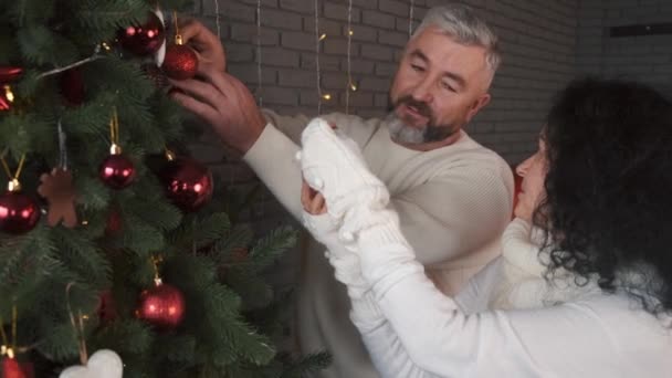 Glada mogna par dekorera julgran tillsammans hemma — Stockvideo