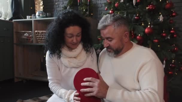 Starší pár otevírá vánoční dárky doma — Stock video