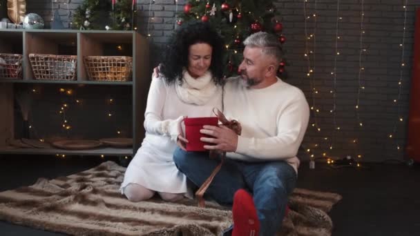 Äldre par öppnar julklappar hemma — Stockvideo