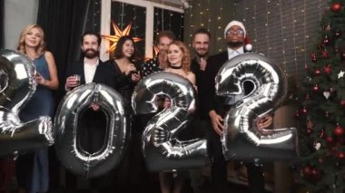 2022 şişirilebilir folyo numaralarını elinde tutan arkadaş grubu.