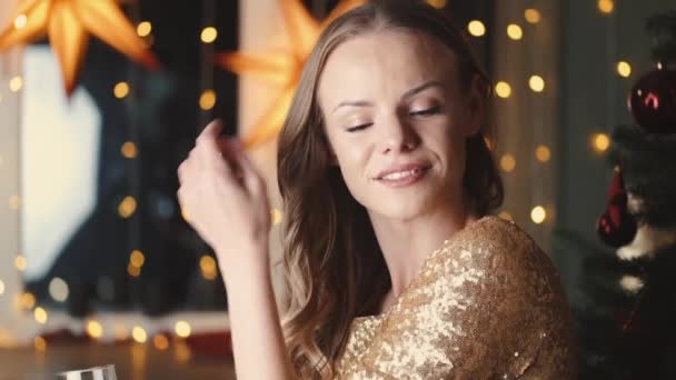 Bonita joven en vestido elegante bebe champán cerca del árbol de Navidad para la fiesta de año nuevo — Vídeos de Stock