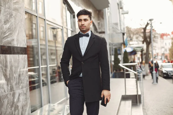 Стильный бизнесмен в черном костюме, стоящий снаружи — стоковое фото