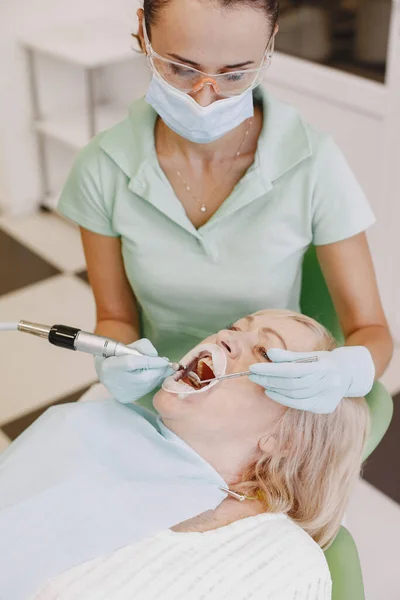 牙医用工具看她的老年病人 — 图库照片