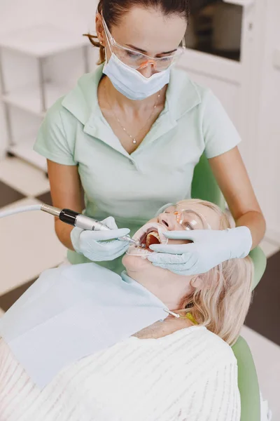 Dentista cercando il suo vecchio paziente con gli strumenti — Foto Stock