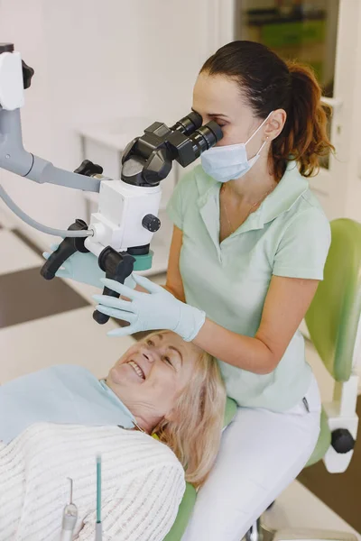 Dentysta patrząc jej stary pacjent z narzędziami — Zdjęcie stockowe