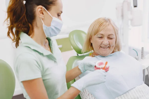 Dentista olhando seu velho paciente com ferramentas — Fotografia de Stock
