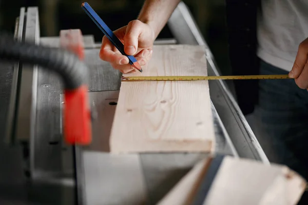 Hombre en el taller con una madera — Foto de Stock