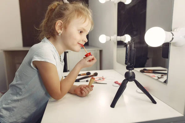 Cute little blogger with cosmetics recording video at home — Stock Photo, Image