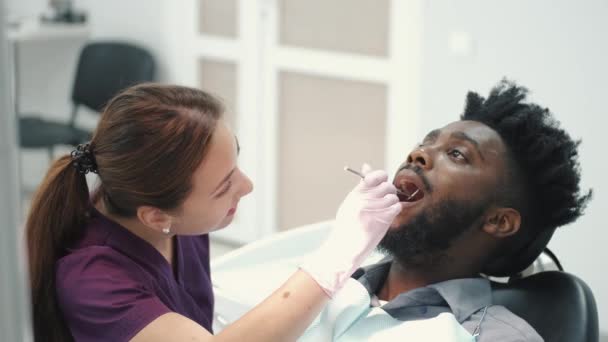 Zubař vyšetření zubů pacientů v ordinaci zubaře — Stock video